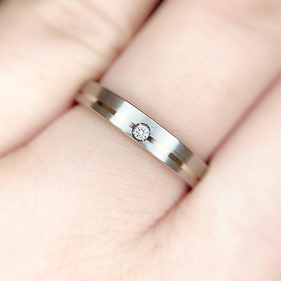 シンプルデザインのリングの中心にセッティングされたダイヤモンドが美しく輝きます。