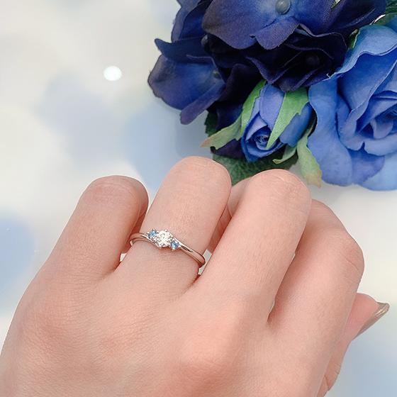 正統派なウェーブラインの婚約指輪。シンプルなデザインの中にイノセントアクアマリンのブルーが光ります。