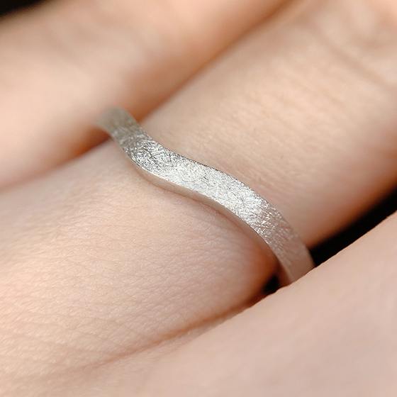 Men'sの結婚指輪。シンプルなウェーブラインと表面加工がさりげなく個性を引き立てるデザインです。