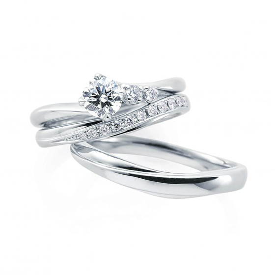 センターダイヤモンドをプラチナのアームで左右から挟んだ細身の婚約指輪。結婚指輪との重ね付けも相性が良い。