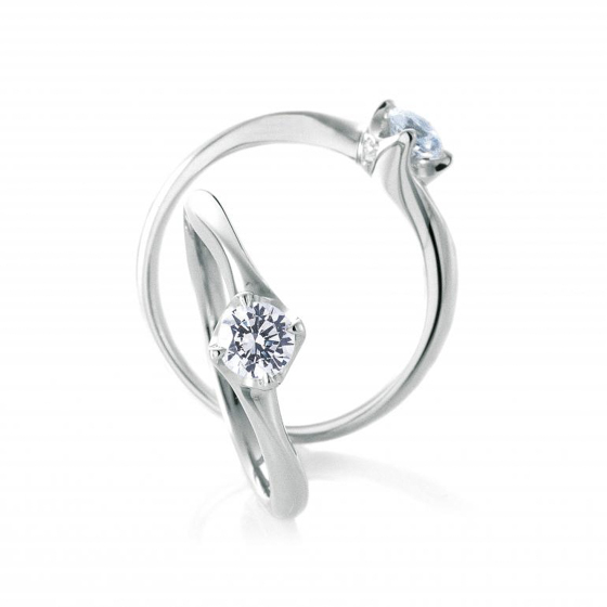 細身のアームでダイヤモンドを津包み込んだような、シンプルな婚約指輪。4点留めでダイヤモンドを四角く演出。