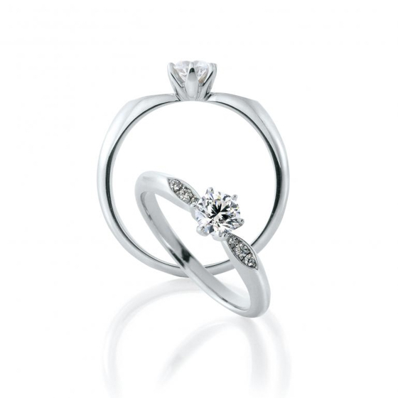 婚約指輪の腕に留められたメレダイヤモンドは大輪の花に寄り添う葉の様。