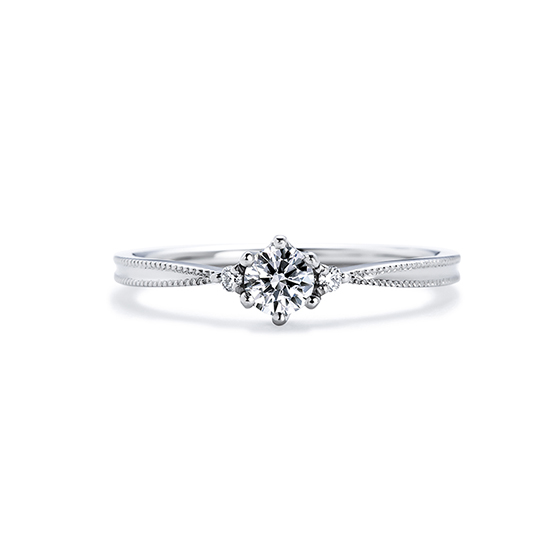 ミル打ちが特徴的な婚約指輪。リングがダイヤモンドに向かってシェイプしているので中央のダイヤモンドを大きく見せてくれる。