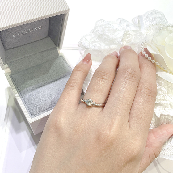 動きのある婚約指輪です。片側に巻き込むようにセットされたメレダイヤモンドが特徴的な婚約指輪。